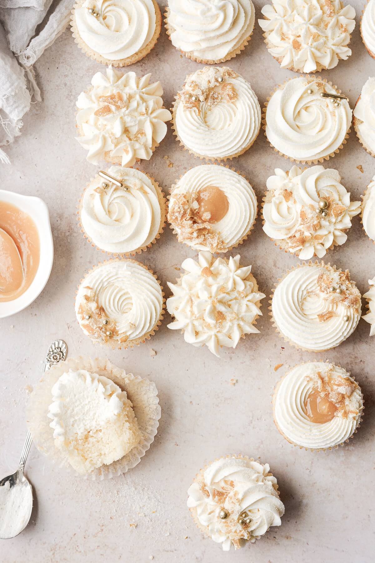 Lemon cupcakes decorated with buttercream, gold sugar pearls and candied lemon peel.