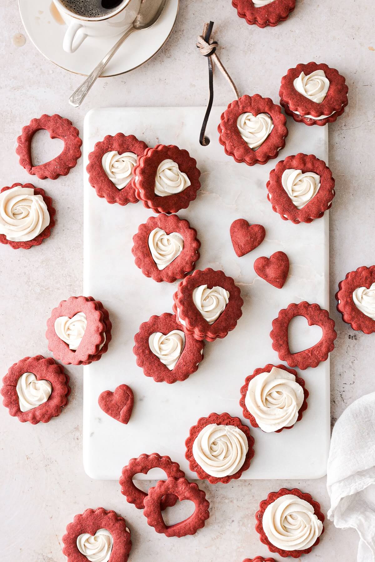 Red and white Valentines Linzer cookies filled with buttercream rosettes.