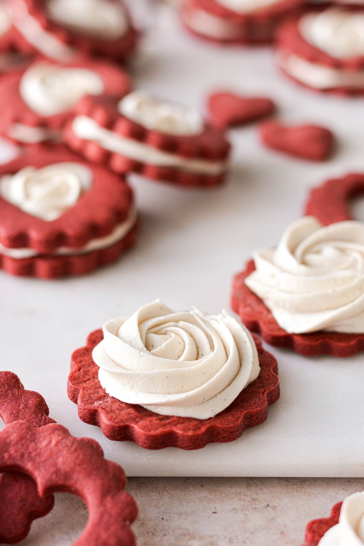 A swirl of buttercream on a red sugar cookie.