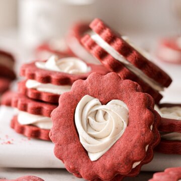 A red and white Valentines Linzer cookie with a heart shaped cutout.