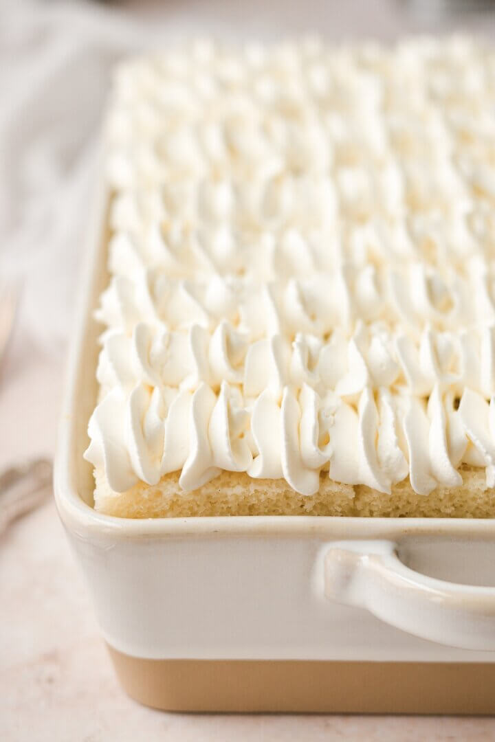 Whipped cream piped on top of a banana pudding cake.