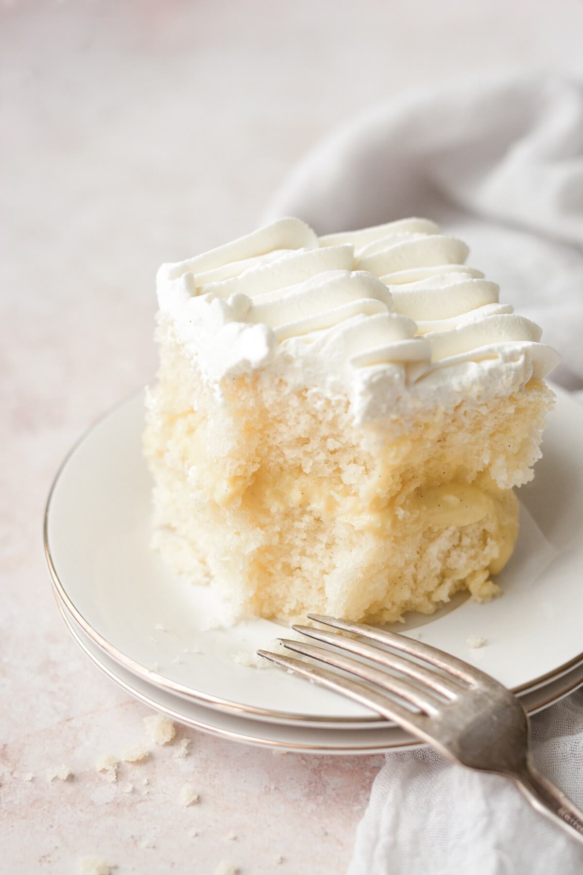 A slice of banana pudding cake with a bite taken.