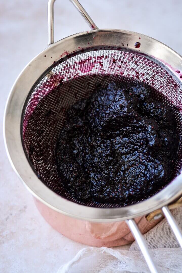 Blueberry juice being strained.