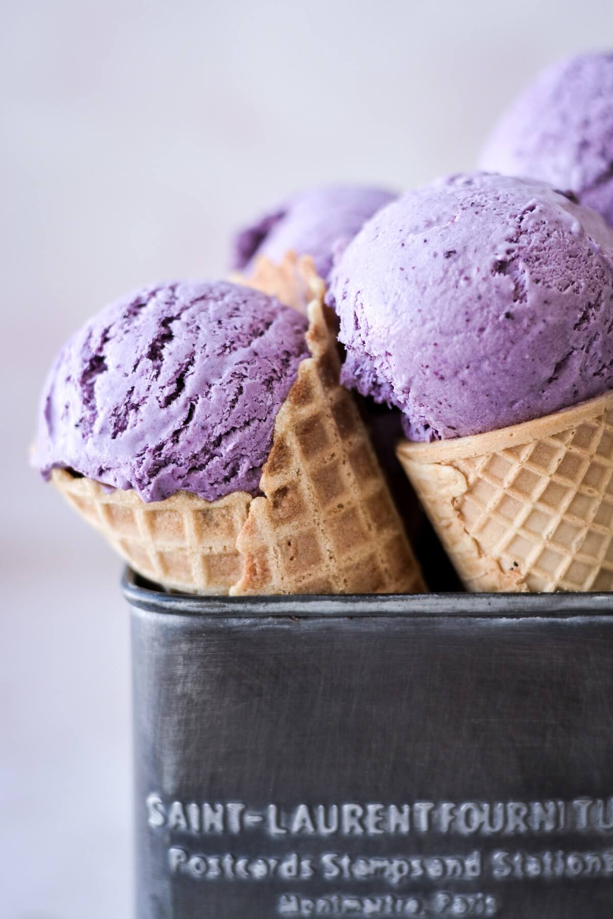 Ice cream cones filled with blueberry ice cream.