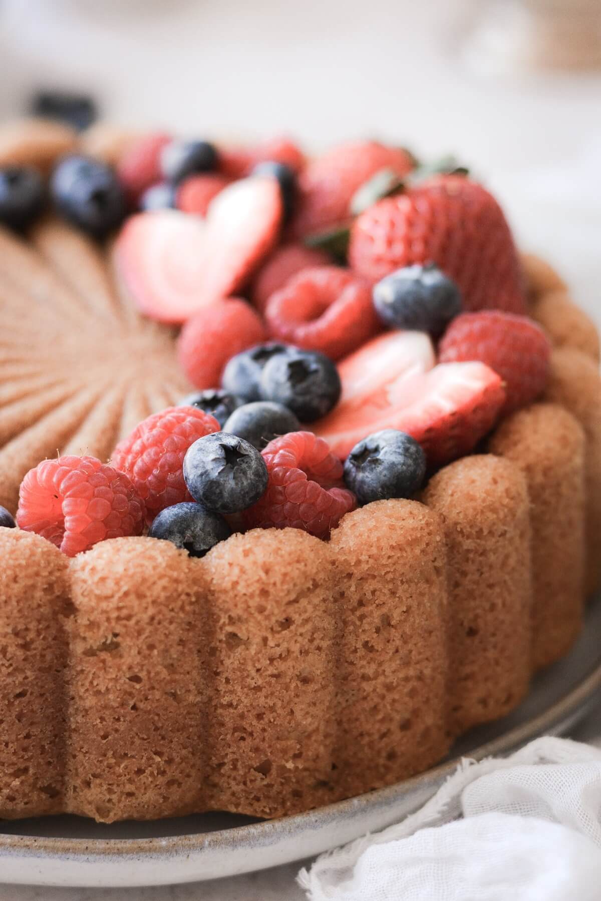 Charlotte cake topped with fresh berries.