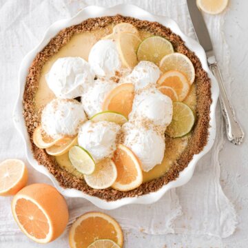 Citrus sour cream pie topped with whipped cream and citrus slices.