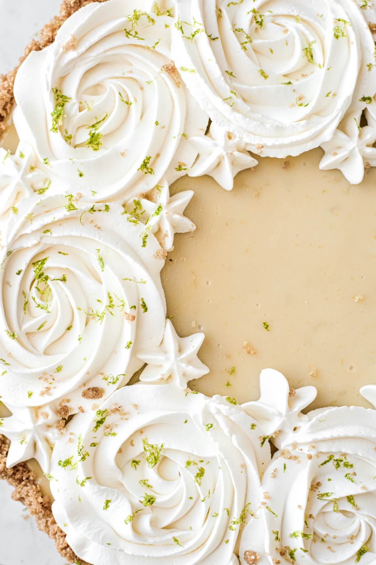 Key lime pie with whipped cream rosettes and lime zest.