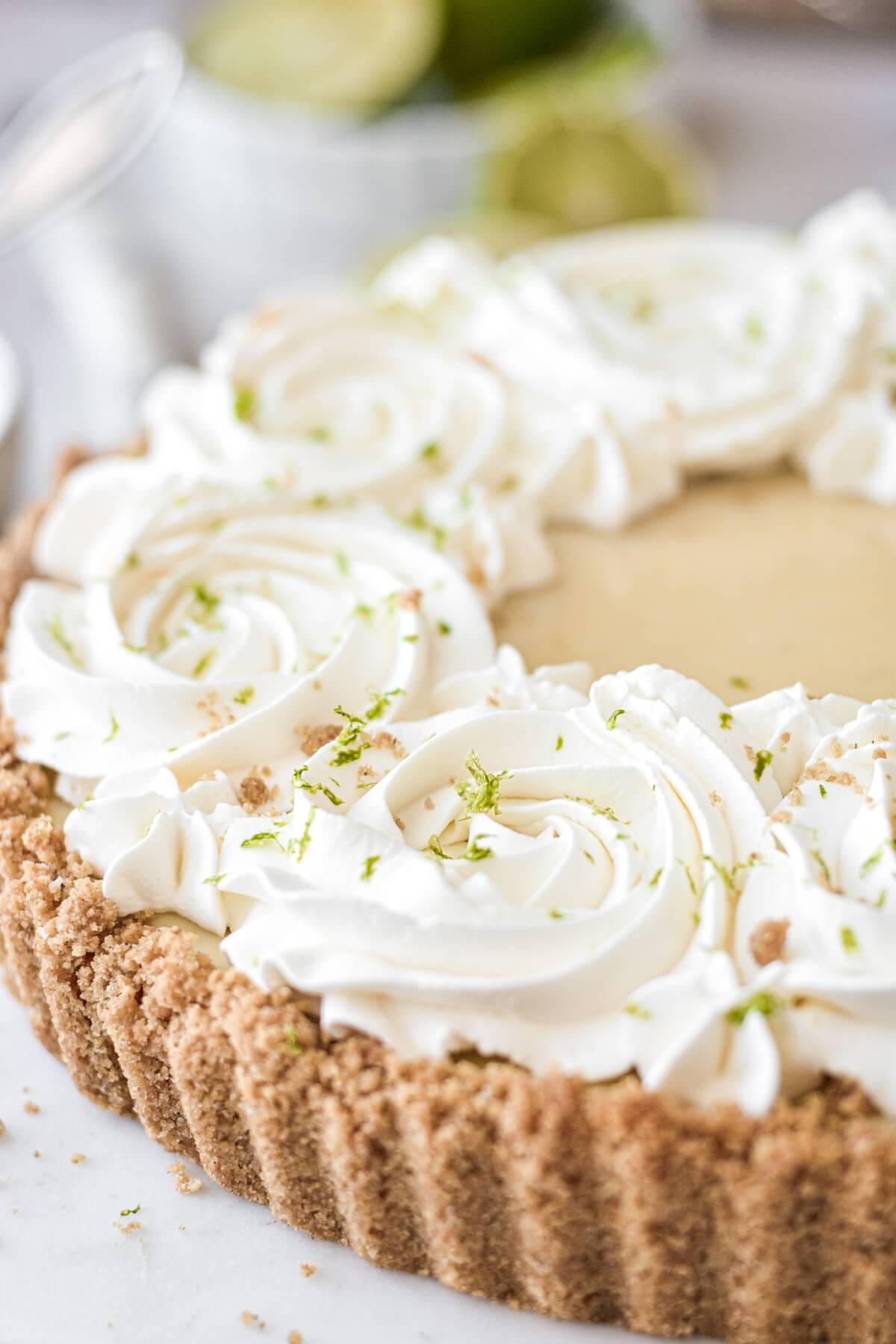 Whipped cream rosettes on top of a key lime pie.