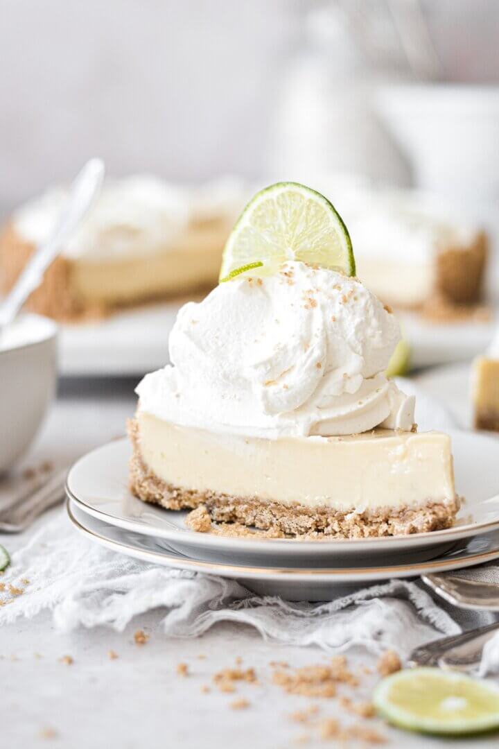 A slice of key lime pie with whipped cream and lime slice.
