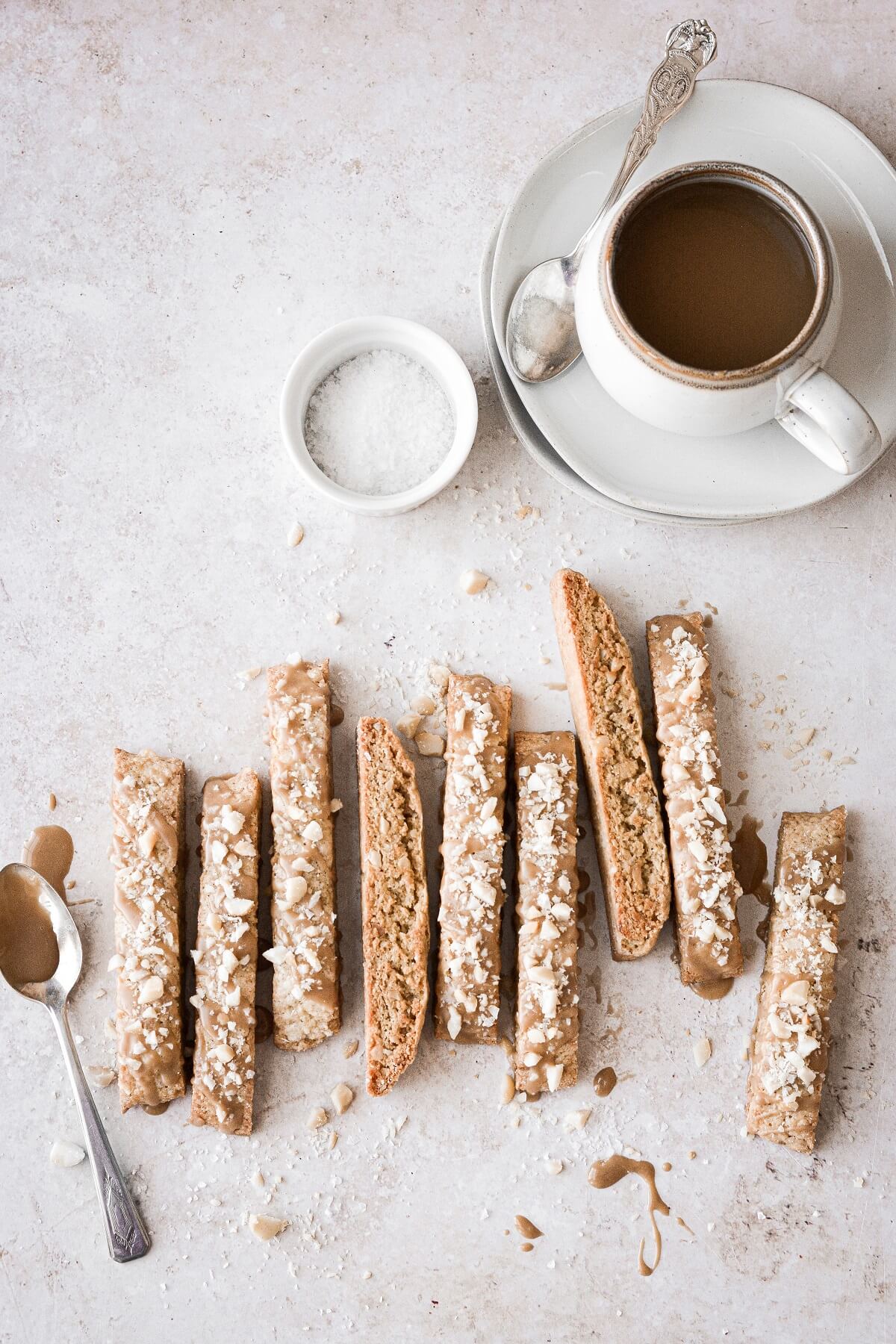 Maple macadamia nut biscotti next to a cup of coffee.