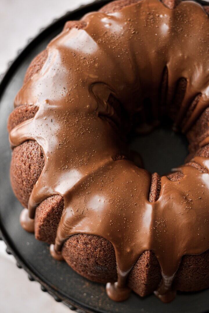 Espresso icing dripping down the sides of a pumpkin bundt cake.