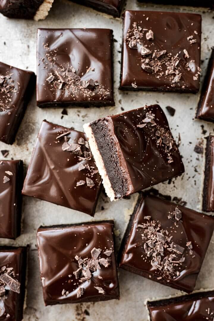 Brownie shortbread bars topped with ganache and chopped chocolate.