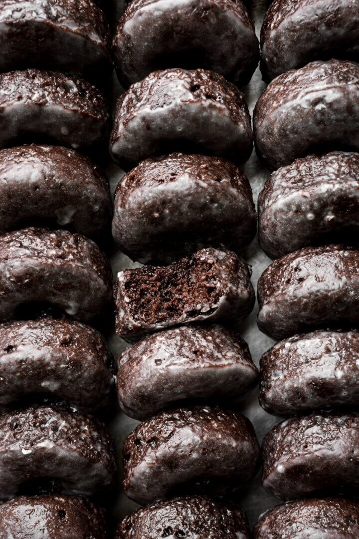 Mini baked chocolate cake doughnuts with vanilla glaze.
