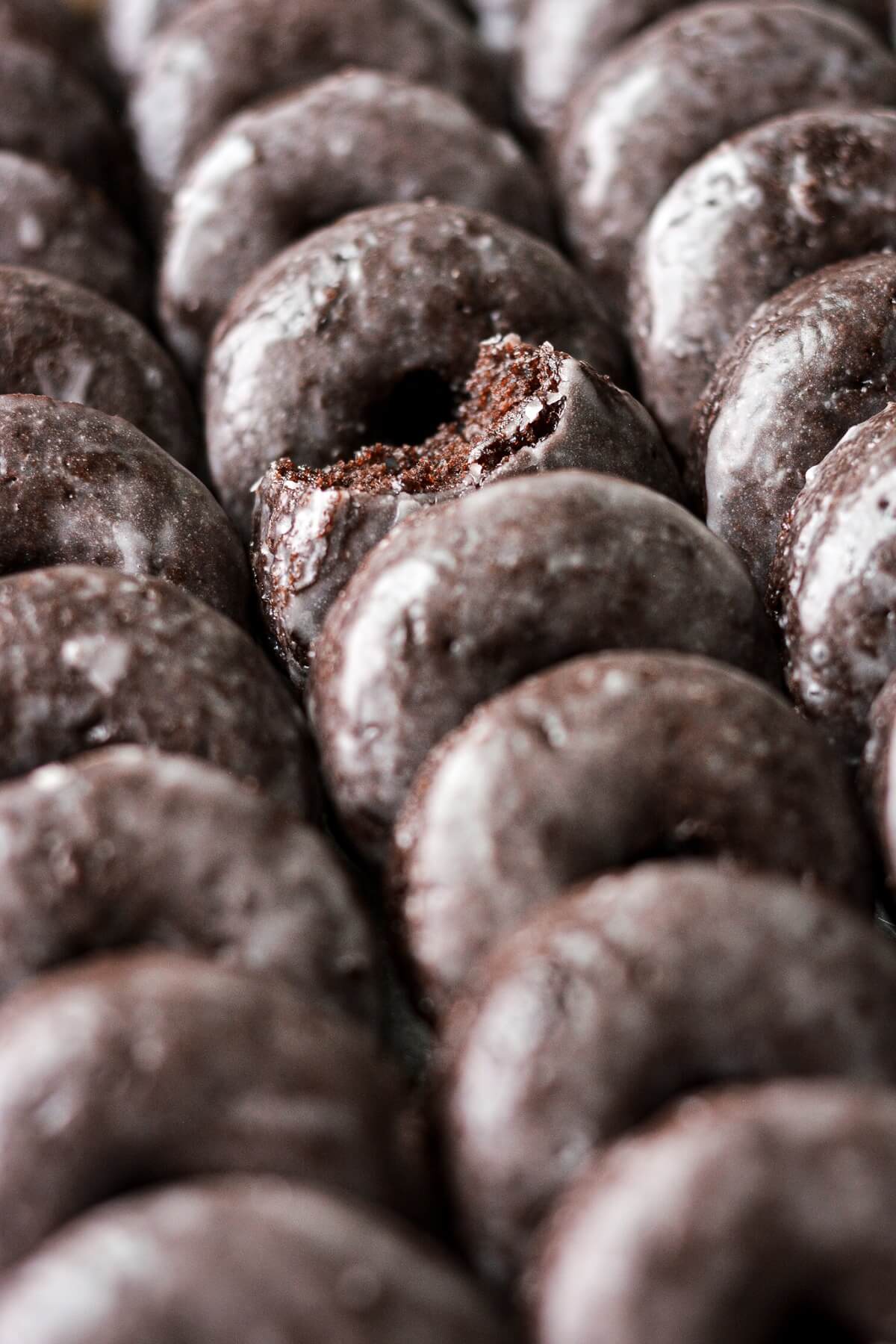 Mini baked chocolate cake doughnuts with vanilla glaze.