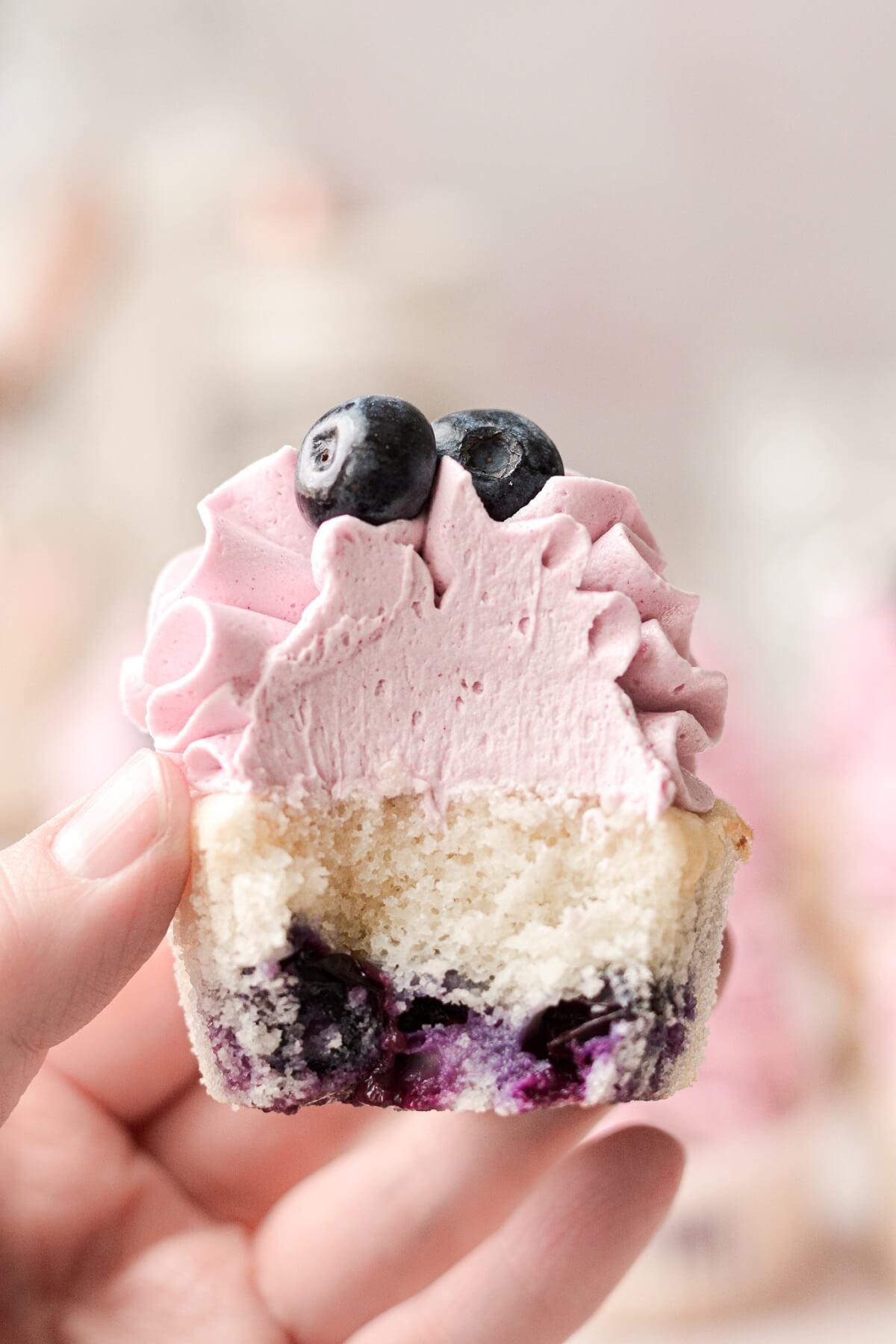 Blueberry cupcake with a bite taken.