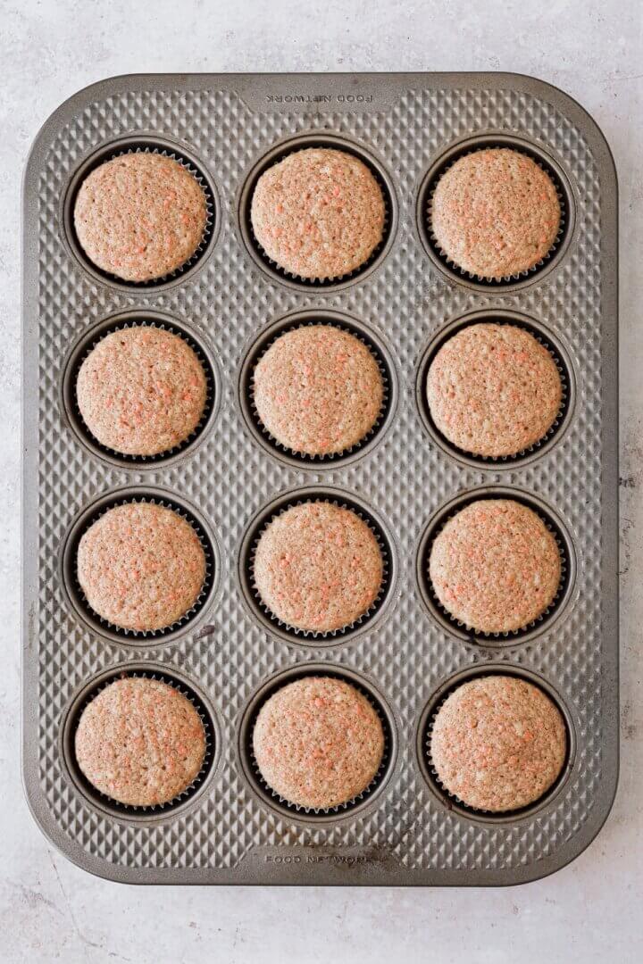 Carrot cake cupcakes in a muffin pan.