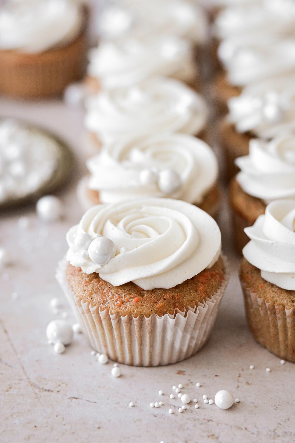 Carrot cake cupcakes with white sugar pearls.
