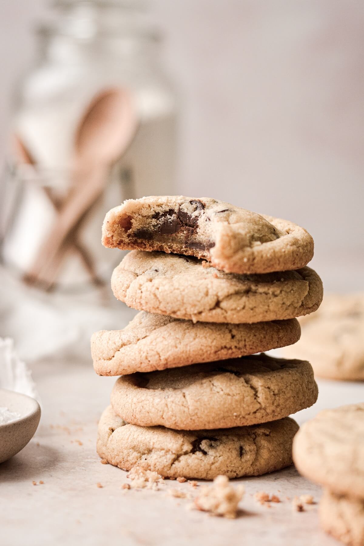 A stack of rye chocolate chip cookies, one with a bite taken.