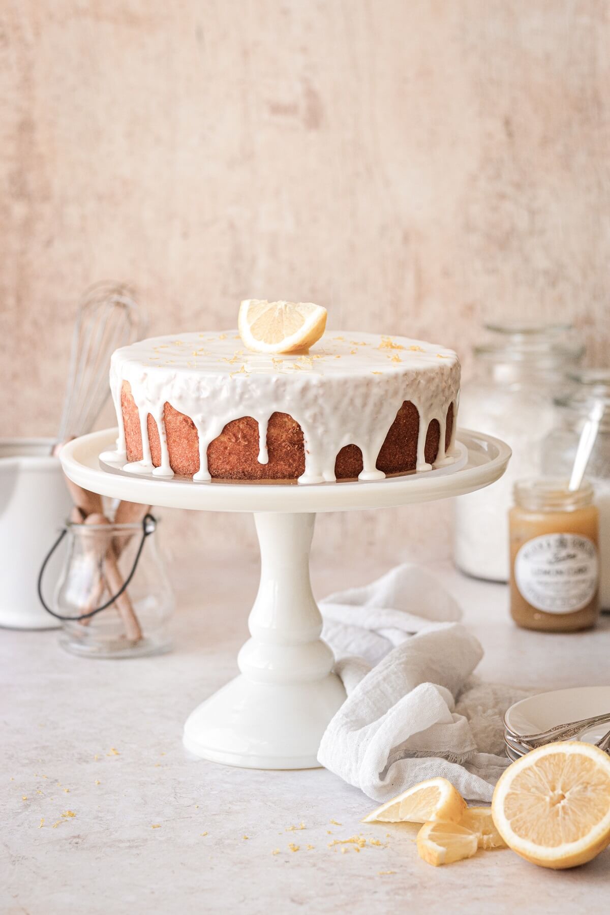 Lemon ricotta cake drizzled with lemon icing and topped with a lemon wedge..