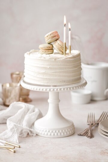Mini vanilla cake topped with birthday candles and French macarons.