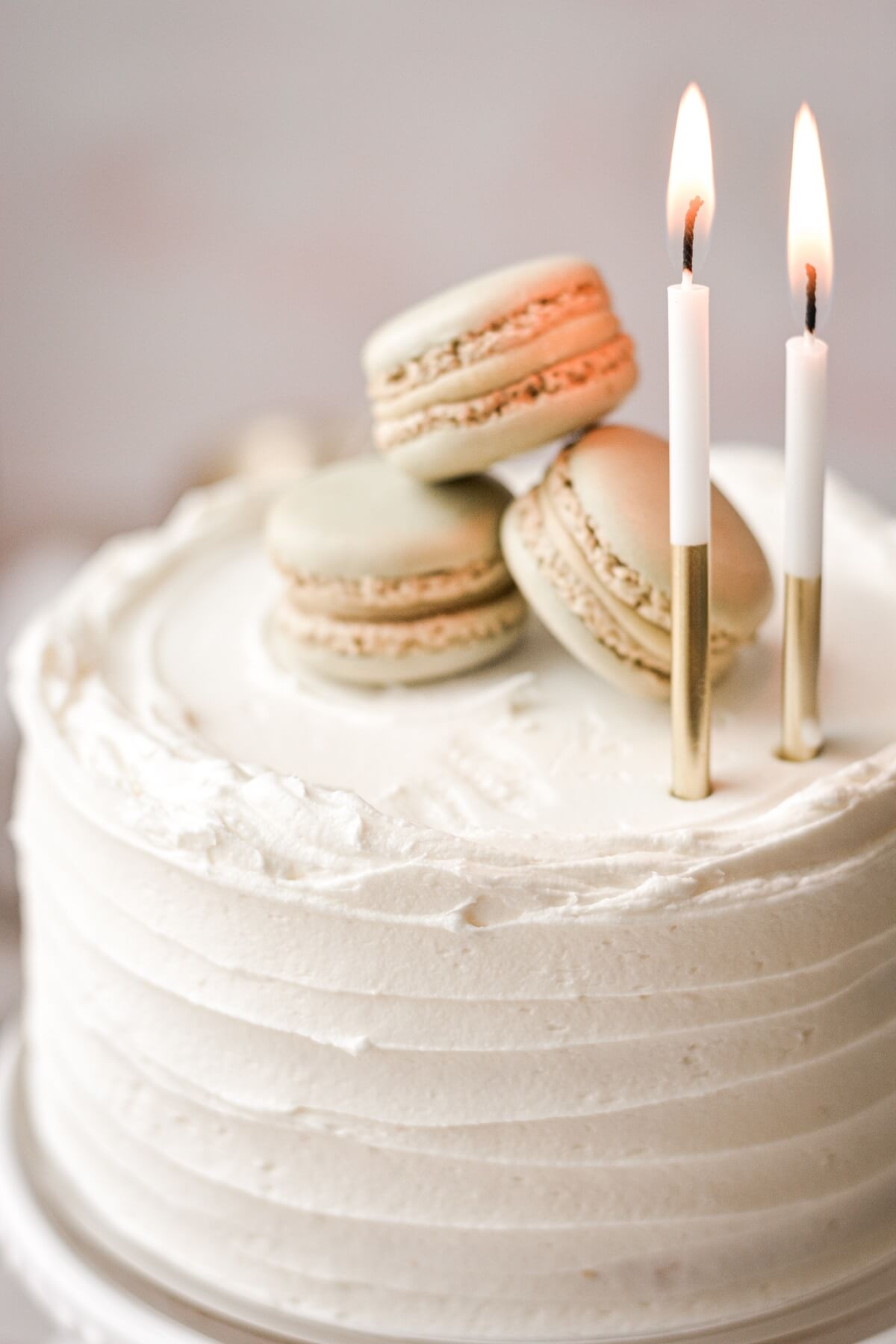 Mini vanilla cake topped with birthday candles and French macarons.