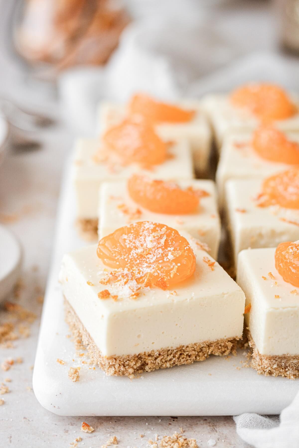Orange creamsicle cheesecake bar topped with a mandarin orange.