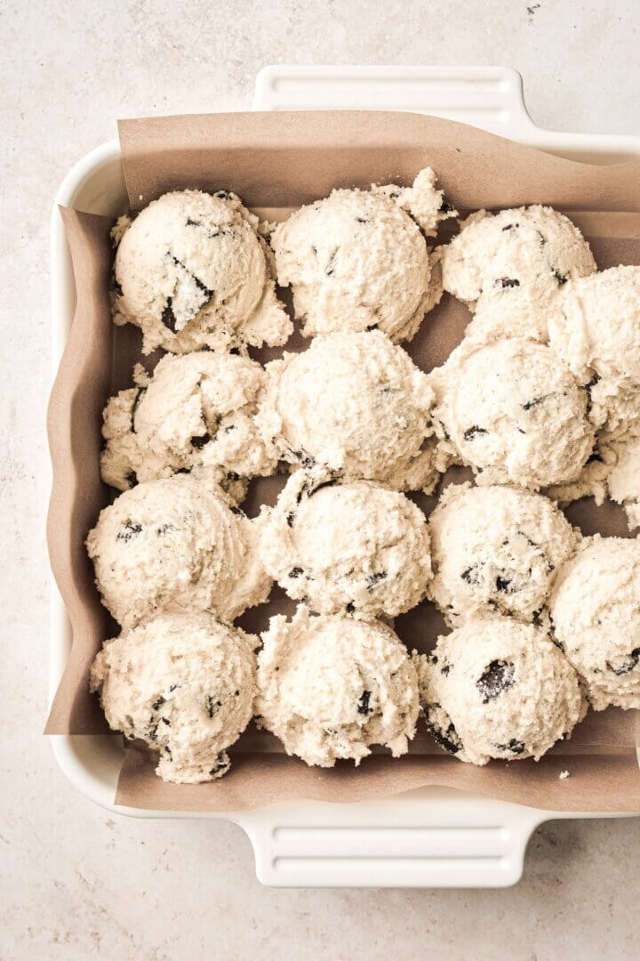 Oreo cookies and cream dough scooped into a baking pan.