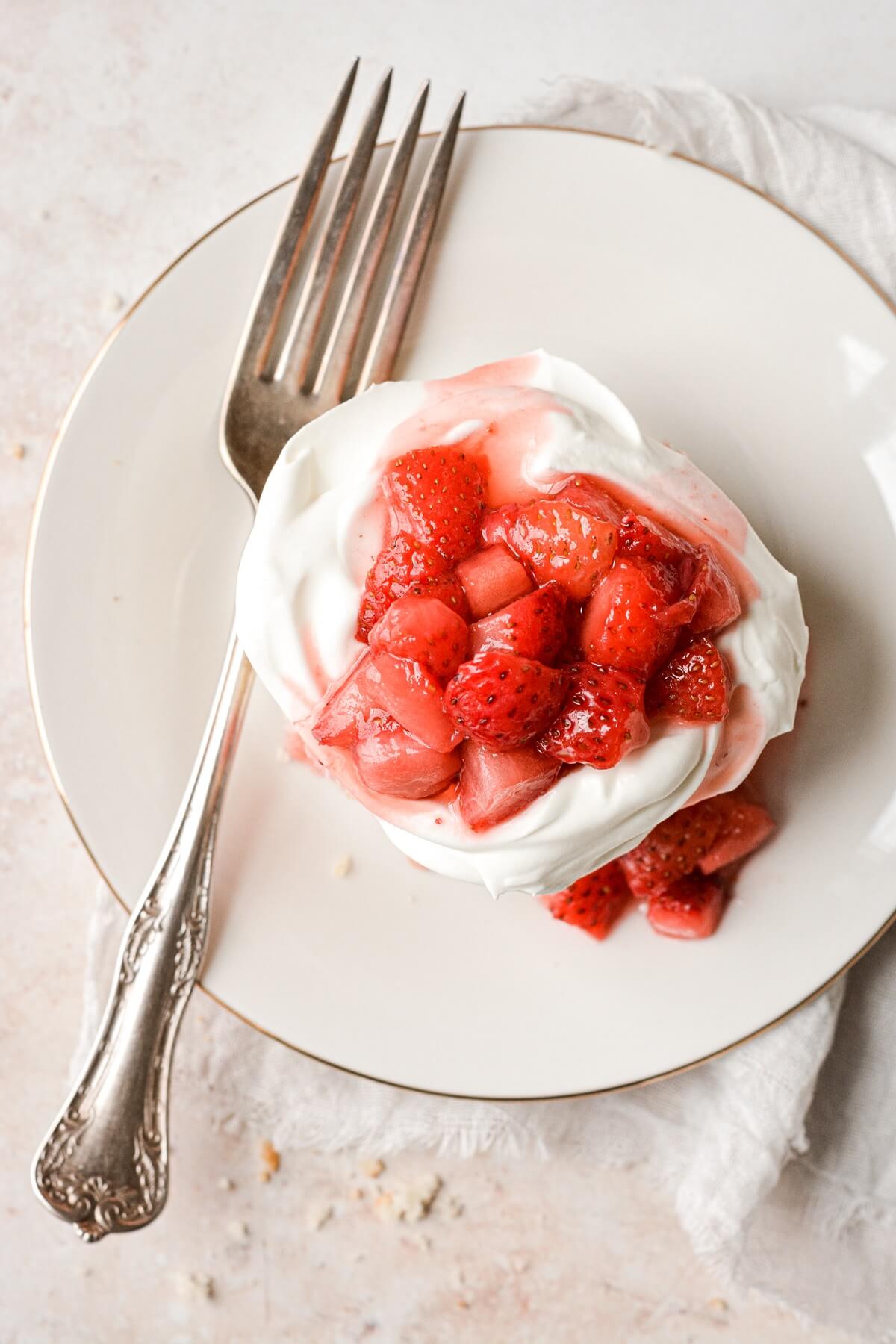 Strawberries and whipped cream on a mini strawberry shortcake.