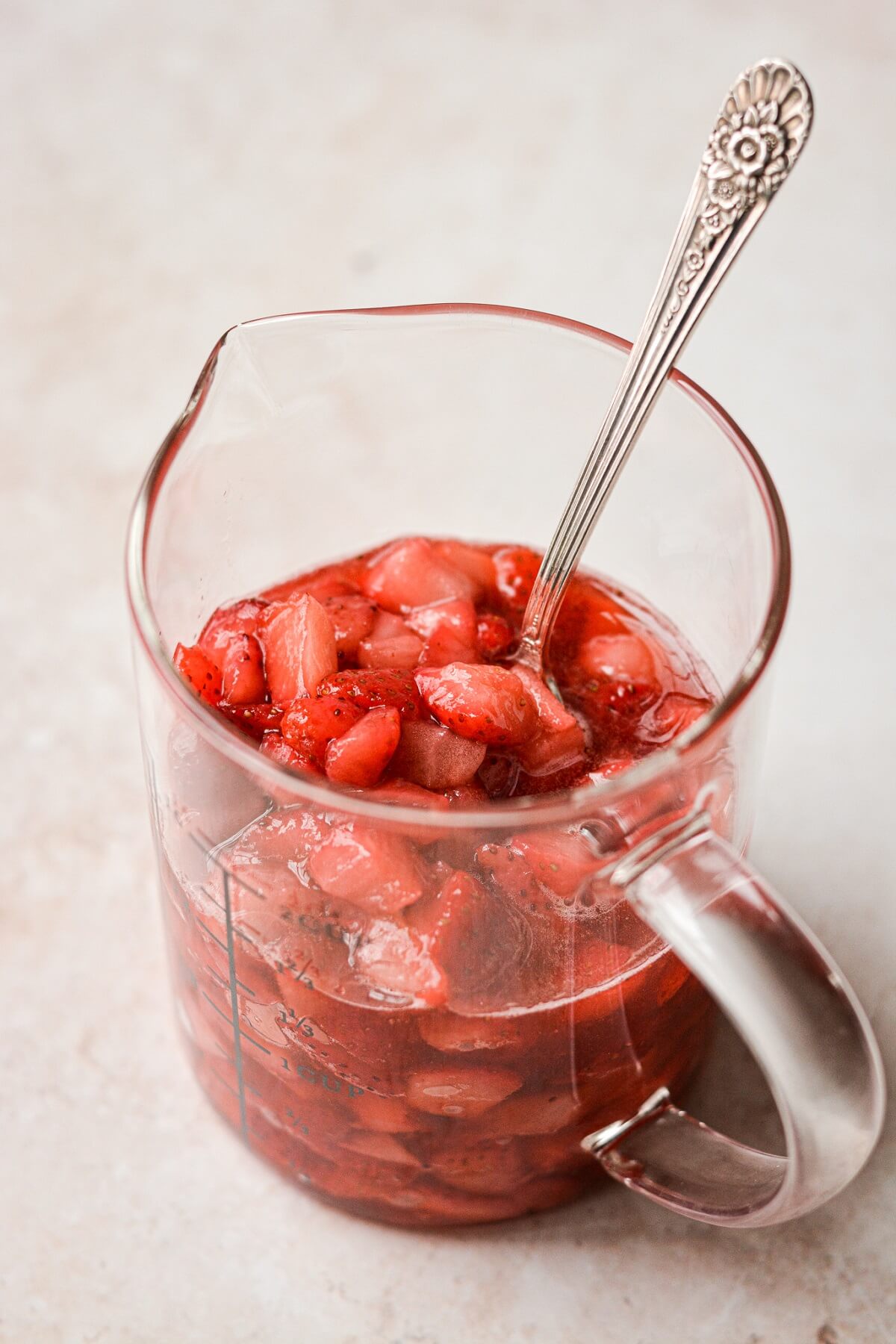 Glass measuring cup of strawberries.
