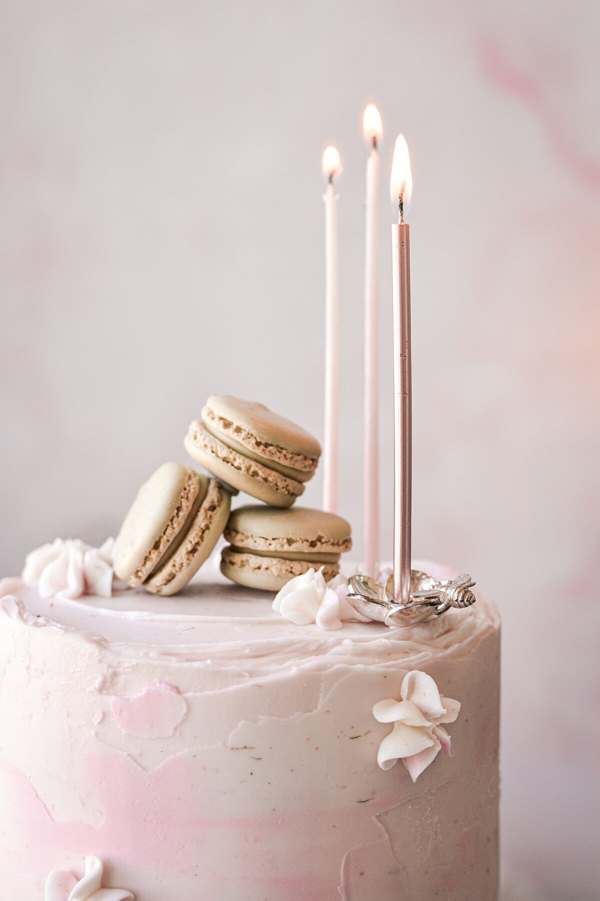 Candles and macarons on top of a cake.