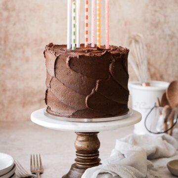 Yellow butter birthday cake with chocolate frosting and candles.