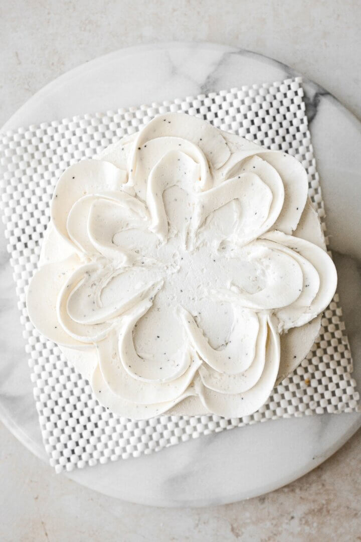 Step 3 for piping a buttercream flower on top of a cake.