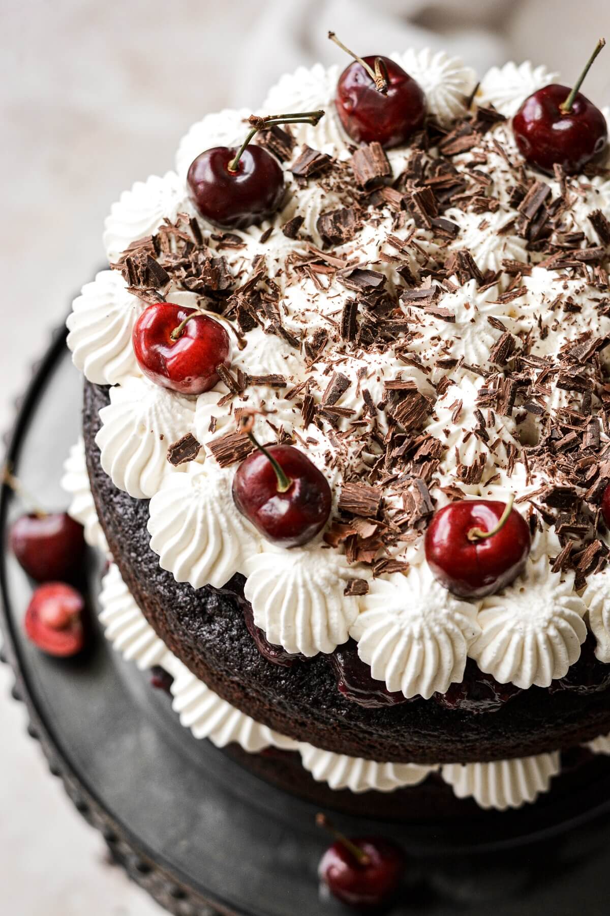 Black forest cake with layers of chocolate cake, cherries, whipped cream and chocolate shavings.
