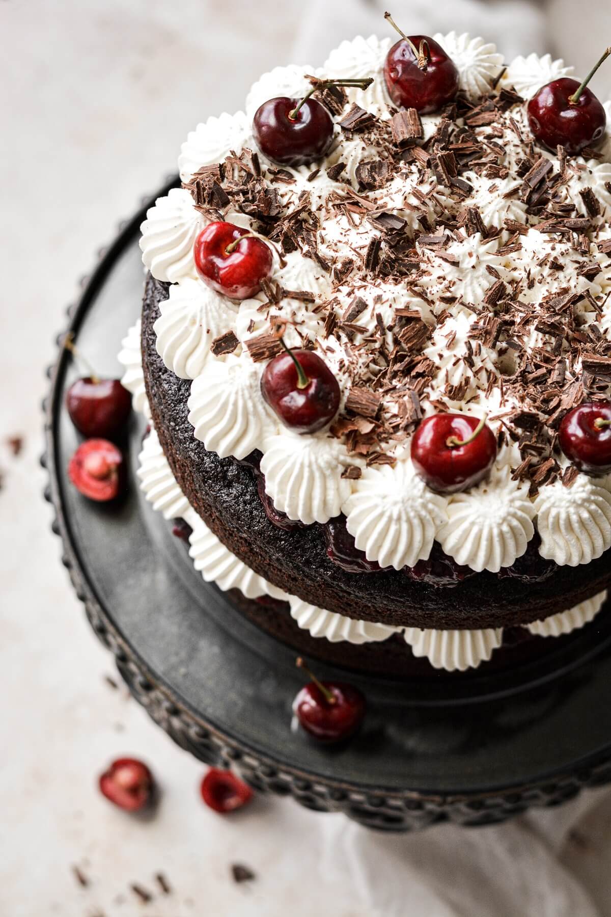 Black forest cake with layers of chocolate cake, cherries, whipped cream and chocolate shavings.