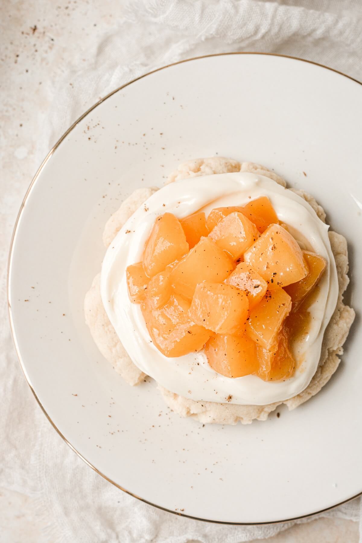 A sugar cookie topped with cream cheese and peach compote.