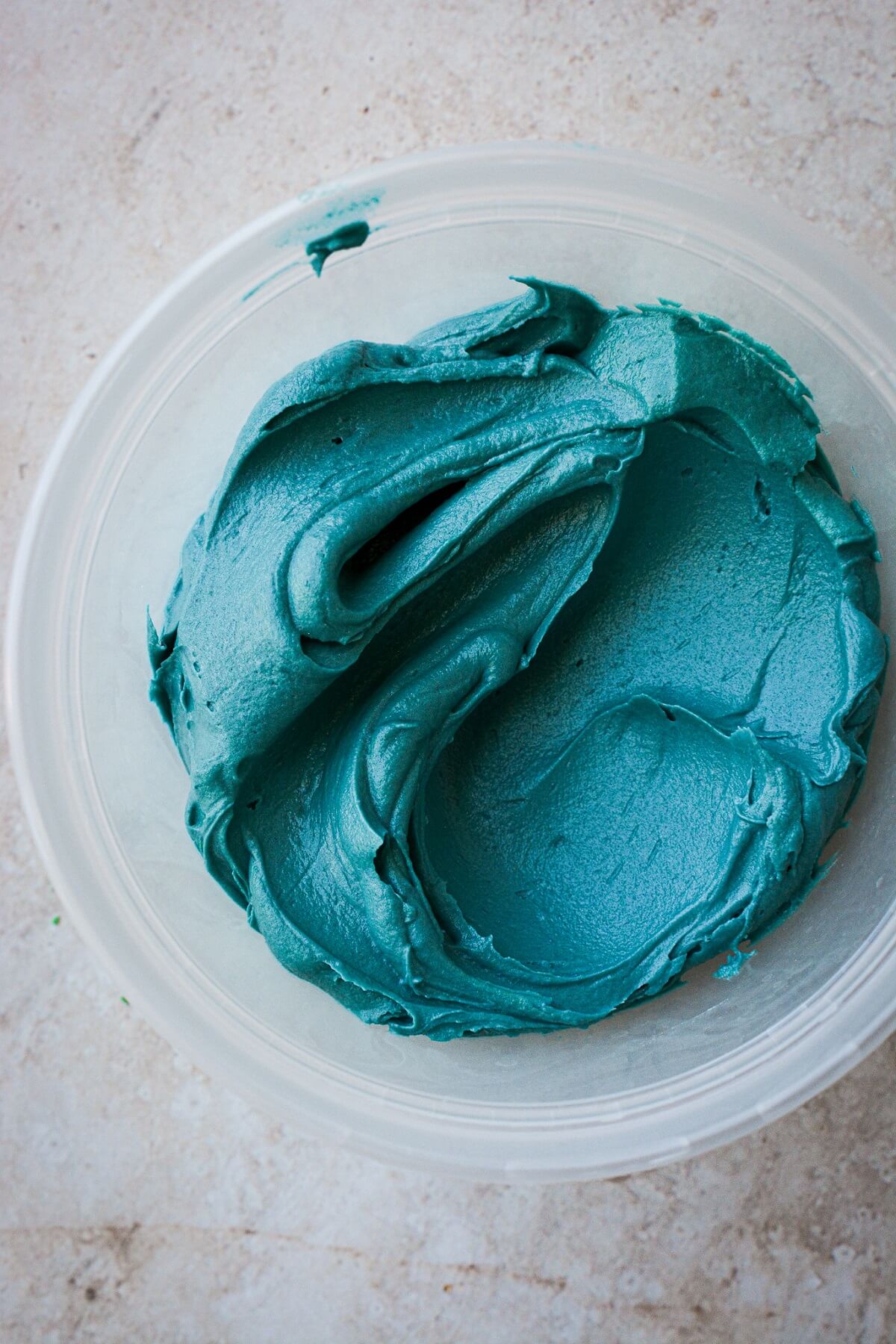 Bowl of deep turquoise blue buttercream.