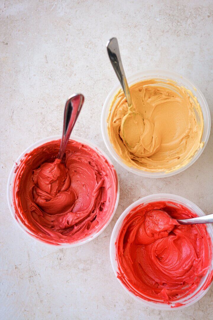 Bowls of red and yellow buttercream.