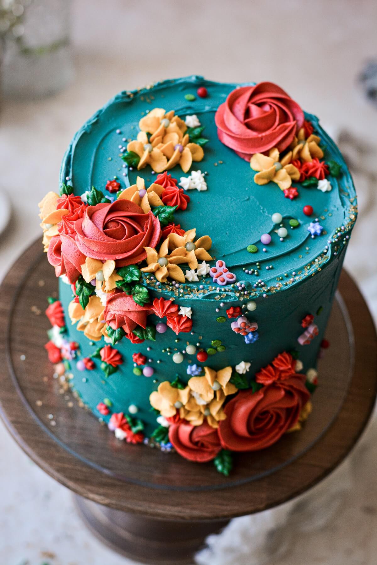 Turquoise floral cake with sprinkles and piped buttercream flowers.