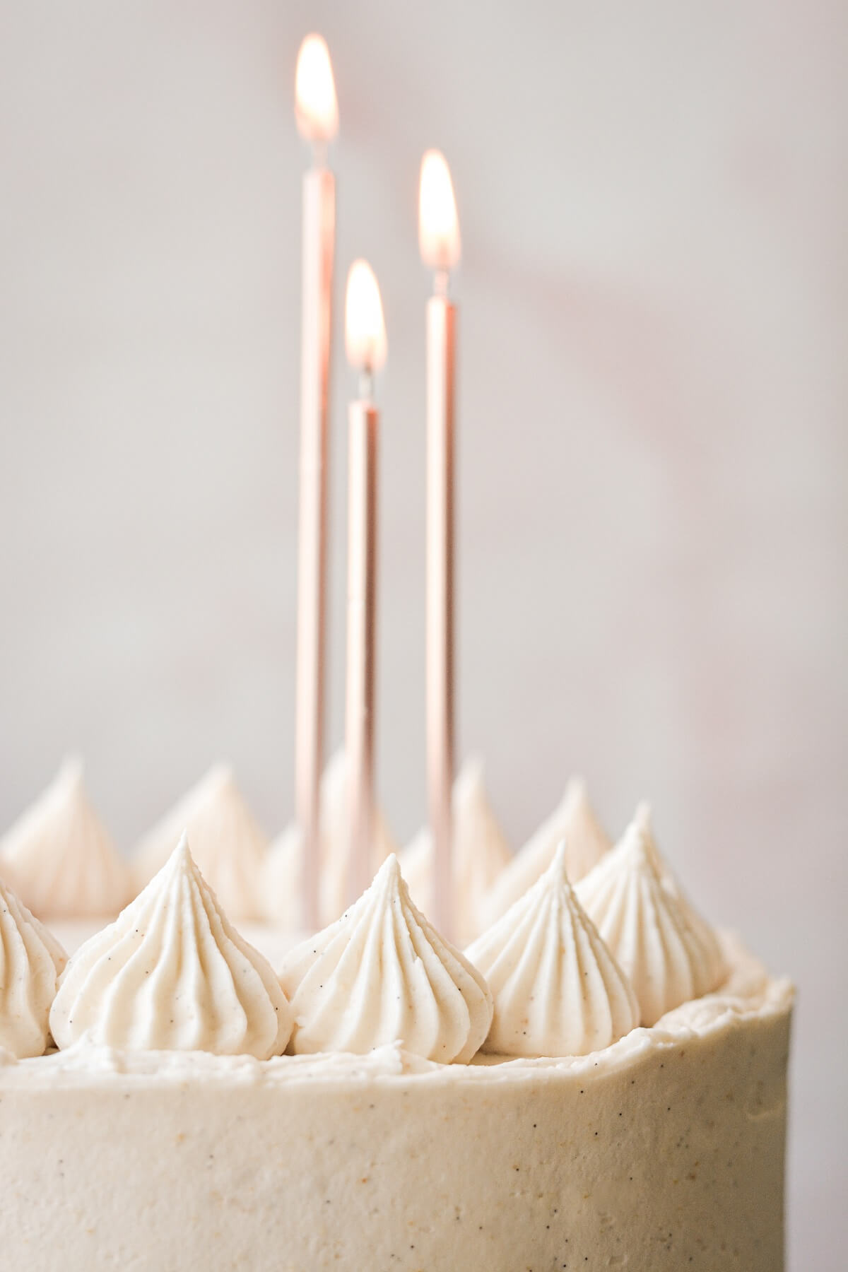 Piped buttercream and birthday candles on a banana layer cake.