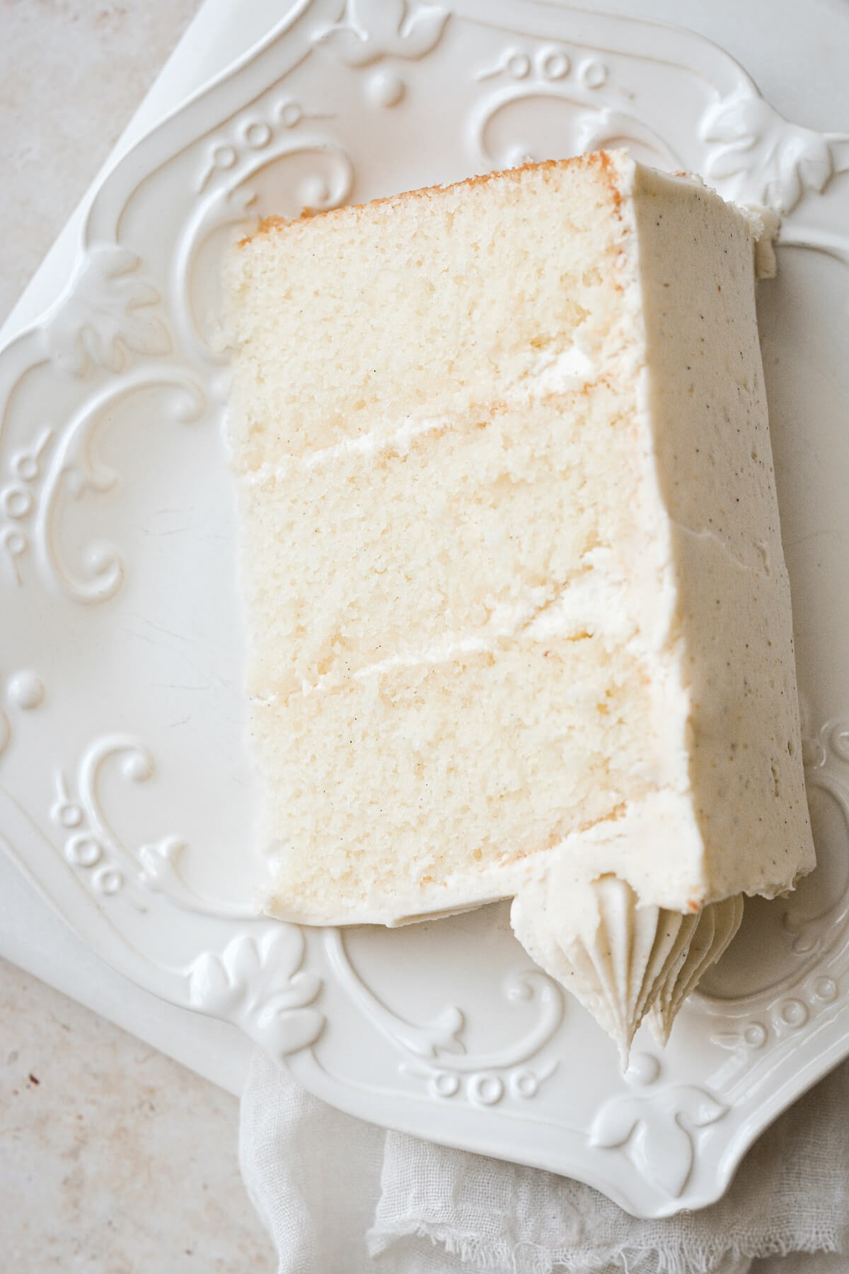 A slice of banana layer cake on a white plate.