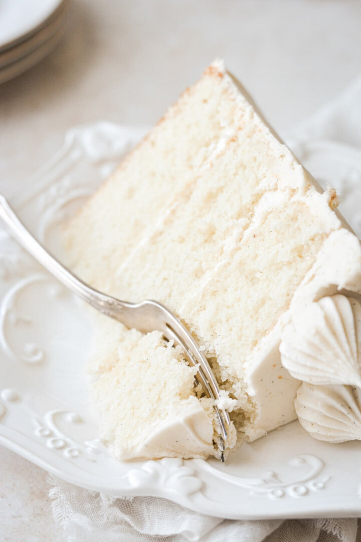 A slice of banana layer cake with a bite taken.