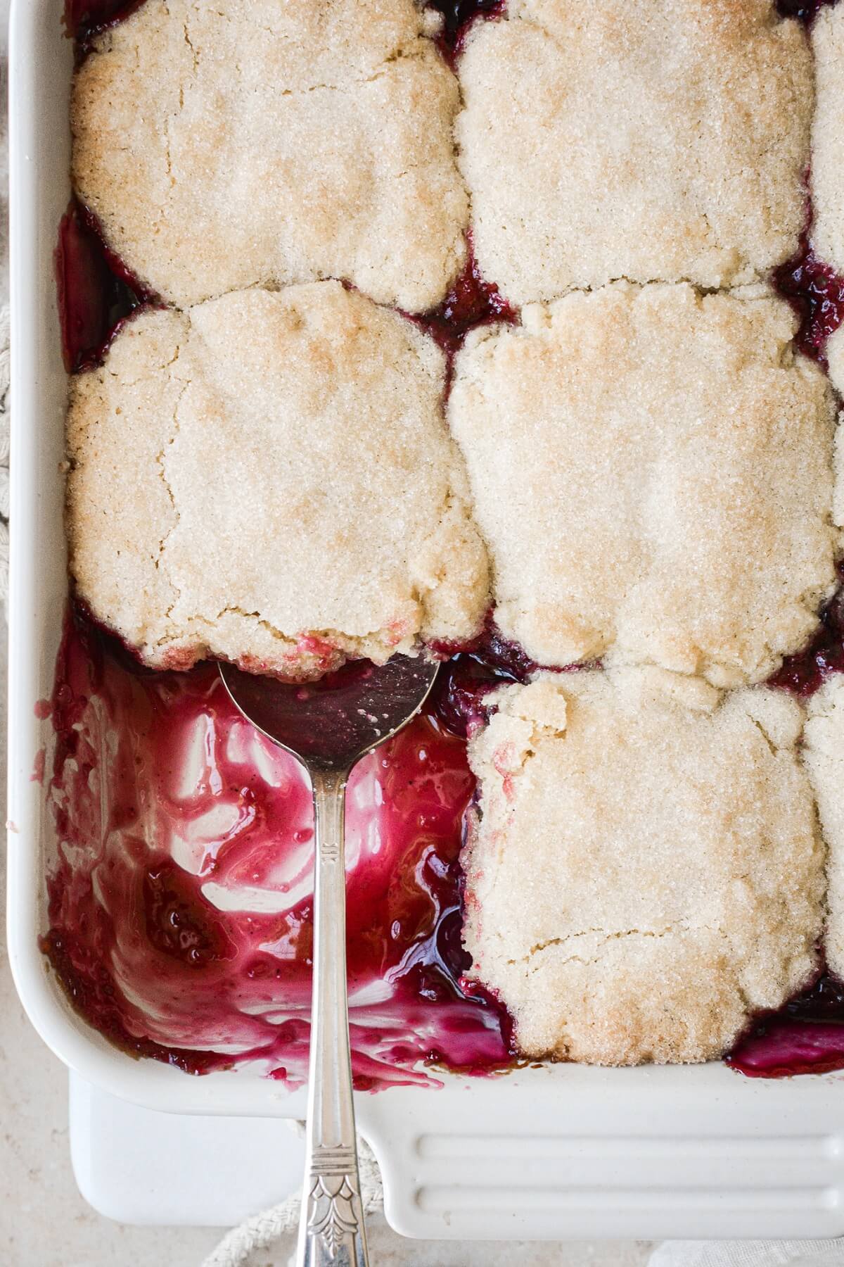 Cherry cobbler in a dish, with one serving taken.