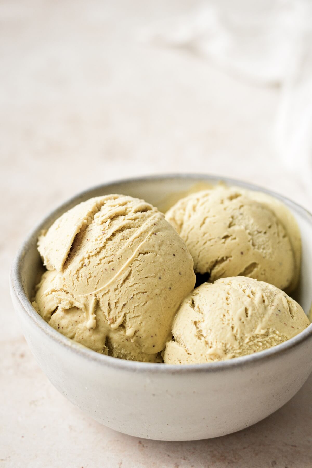 Scoops of no churn pistachio ice cream in a bowl.