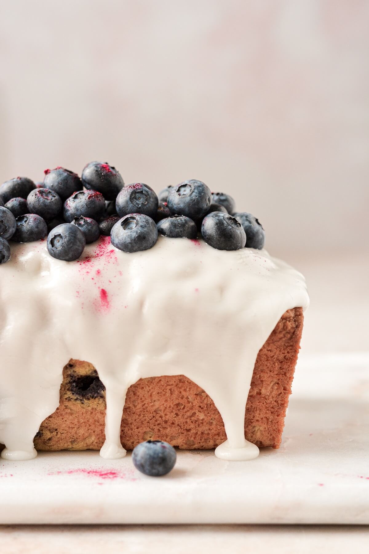 Lemon blueberry loaf cake with lemon icing and fresh blueberries on top.