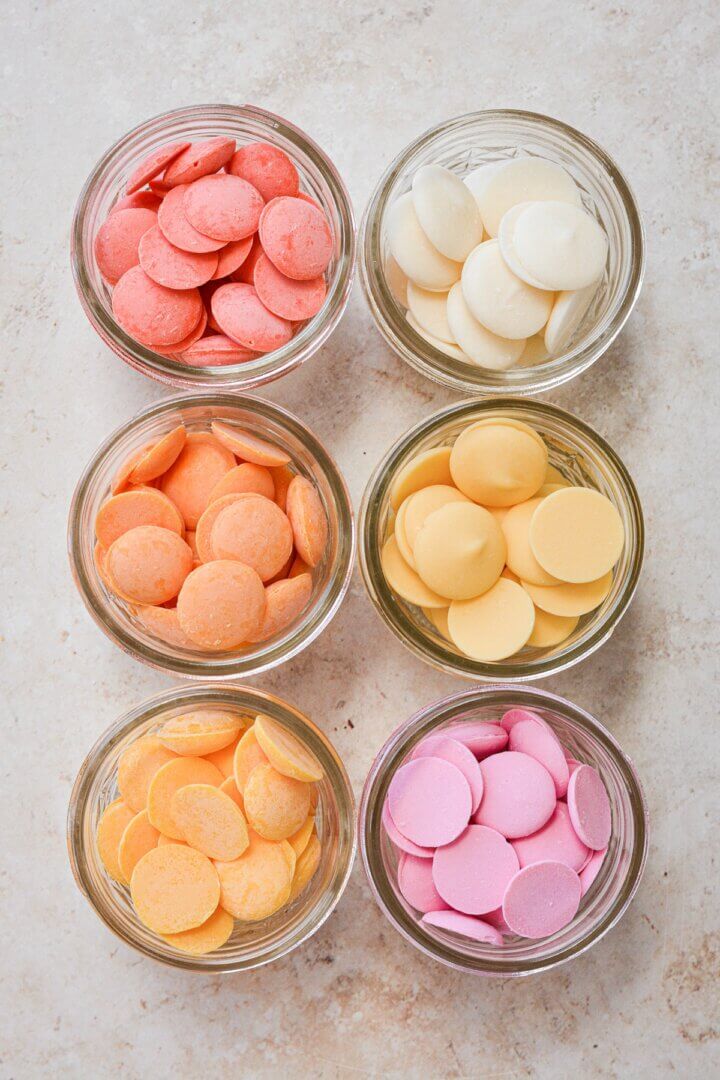 Colorful candy melts in glass jars.
