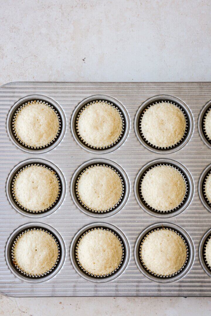 Vanilla cupcakes in a cupcake pan.