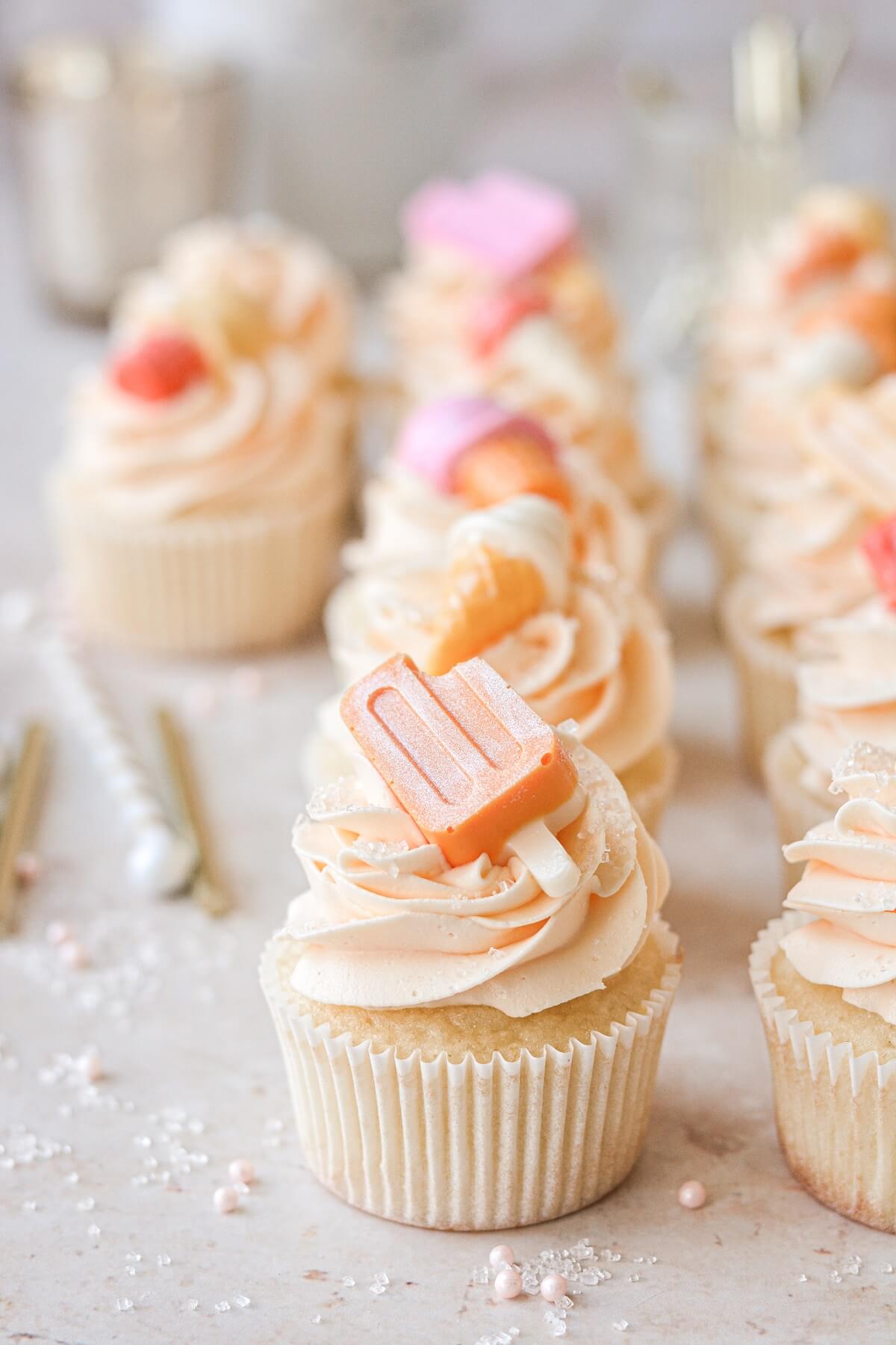 Popsicle cupcake topper on orange creamsicle cupcakes.