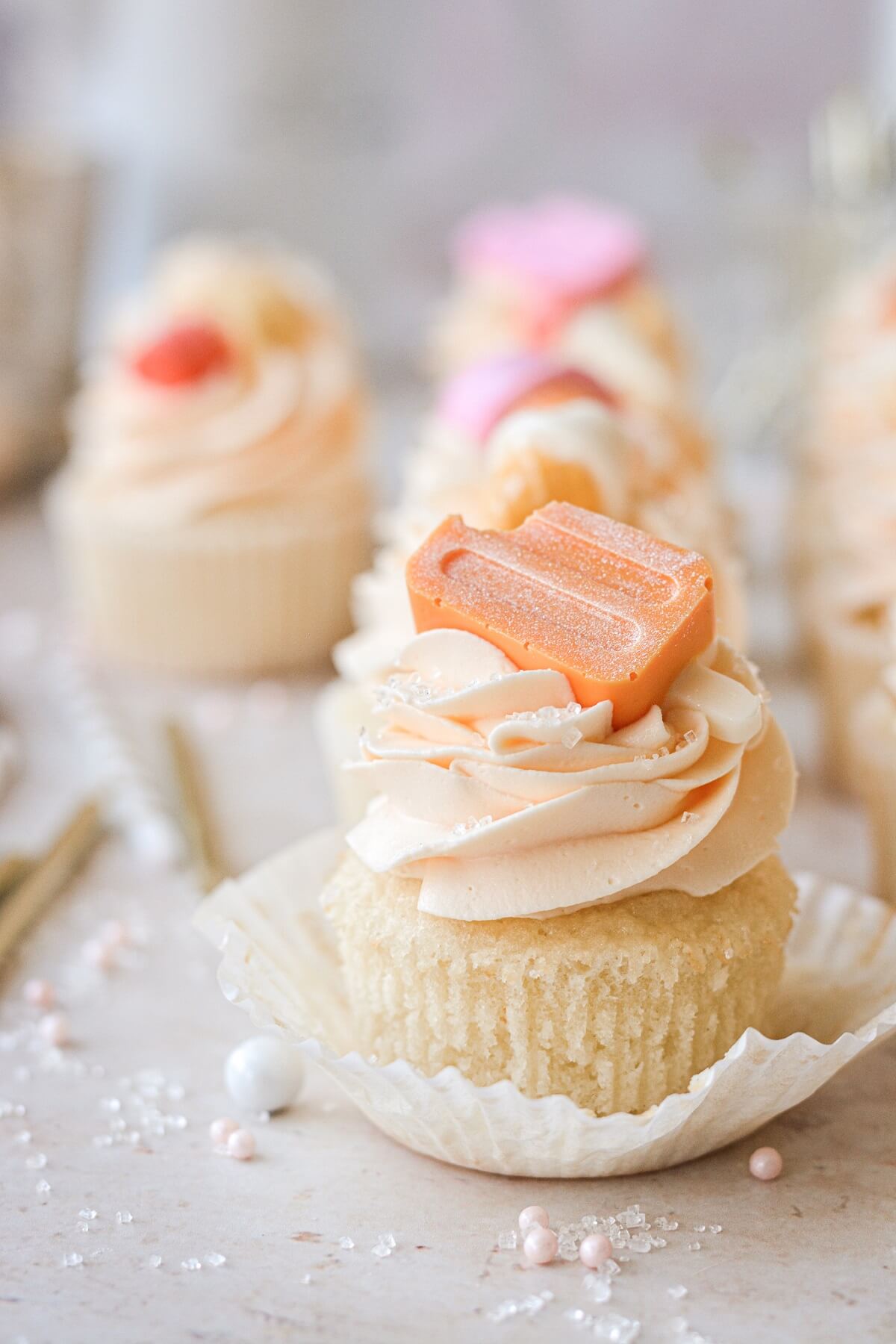 An orange creamsicle cupcake with the wrapper unwrapped.