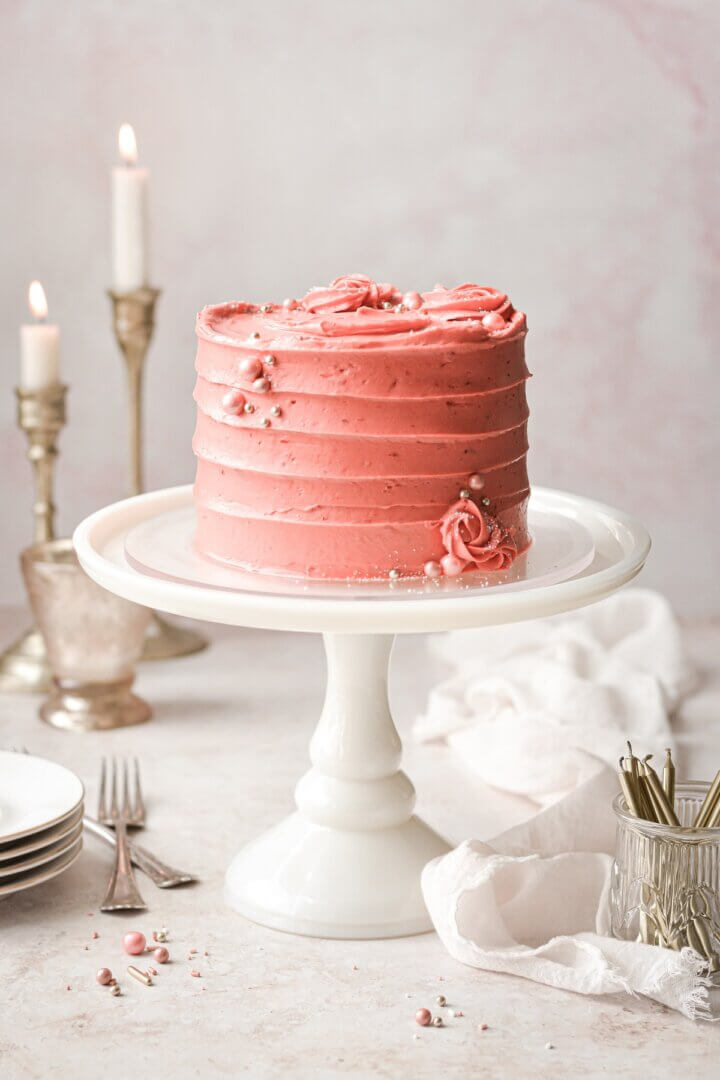 Strawberry cake with piped roses and sugar pearls.