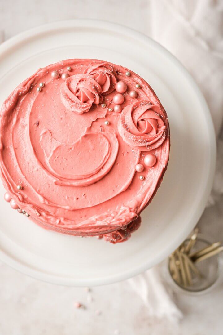 Piped rosettes and sugar pearls on a strawberry cake.